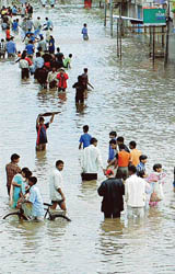 Residents wade through the submerged Maruti road at Sangli, 360 km south-east of Mumbai, on Tuesday