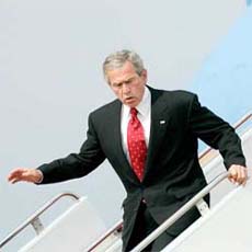 President George Bush reacts as he stumbles while walking off Air Force One after returning to Andrews Air Force Base, Washington