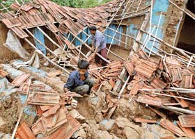 Villagers search for their belongings among their wrecked houses in Kanzar village, about 100 km south of Ahmedabad