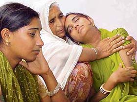 A relative consoles Simran Kaur and Manjit Kaur, daughters of Jasbir Kaur who died in a bus accident, at their residence in Daffarpur village, near Ramgarh