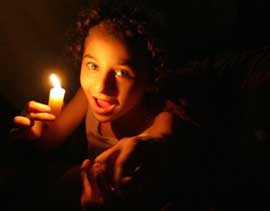 A Lebanese girl holds a candle while watching the speech by Hezbollah leader Sayyed Hassan Nasrallah in downtown Beirut on August 3. 