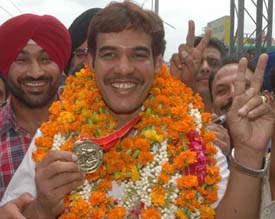 Randhir Singh Dhira flashes the victory sign at the Jalandhar railway station on Tuesday