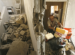 A Lebanese man retrieves personal belongings amid the rubble of his flat destroyed by Israeli bombardment in Shiah, a suburb of southern Beirut