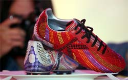 A photographer takes pictures of a shoe pair decorated with crystals at the presentation of crystal temptation shoe collection in Bangkok on Wednesday.