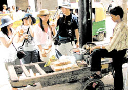 Tourists from South Korea enjoying the taste of Indian tea at a roadside tea stall in Chawri Bazar in the Capital.