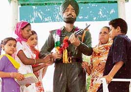 Sisters of Naik Paramjeet Singh tie rakhis on his statue on the occasion of Rakhi in Gill village on Wednesday.