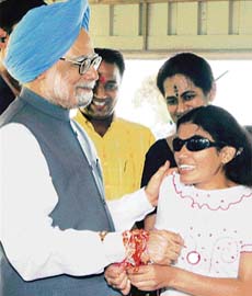 A visually challenged schoolgirl ties a rakhi on the wrist of Prime Minister Manmohan Singh at his residence in New Delhi on Raksha Bandhan