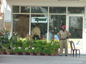 Income Tax officials inspect records at a petrol station on the Old GT Road, near Chand Cinema, as a policeman stands guard, in Ludhiana on Thursday