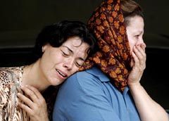 Women mourn after a rocket hit a house in northern Israeli town of Deir al-Assad