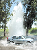 A car trying to cross the fountain caused by a burst in water pipeline near the bank of the Yamuna river in the Capital