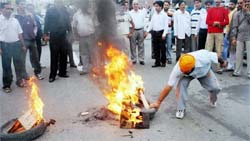 A lawyer grabs a burning tyre during a demonstration by members of the Jammu Bar Association demanding transfer of the Srinagar sex scandal case to Jammu on Friday.