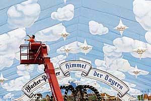 A man works at a huge beer tent's roof of a German brewery, reading "The heaven of the Bavarians", on Friday in Munich