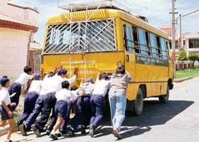 Students of Sir Maculiff High School push the bus which should have carried them home after a painting competition at a school in Mohali