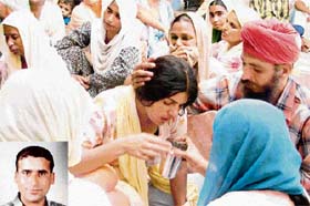 Family members mourn the death of Heera Singh (inset), who was killed in a road accident in South Korea, at Banur