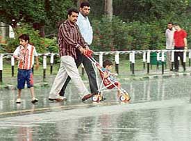 Tourists enjoy a walk in the rain near the Sukhna Lake in Chandigarh on Sunday