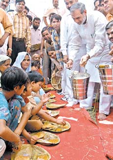 Outer Delhi MP Sajjan Kumar serving food at Madan Giri on the occasion of the release of water from the Sonia Vihar Water Treatment Plant in the Capital