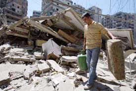 A man carries his belongings as he walks through the rubble of a building in a southern suburb of Beirut on Sunday