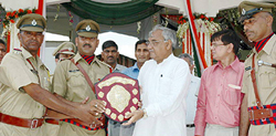 Haryana Chief Minister Bhupinder Singh Hooda presents a shield to policemen for their performance during the Independence Day celebrations in Gurgaon on Tuesday