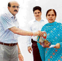 Mr K. D. Chudhry, Chief Engineer, Central Division, Punjab State Electricity Board, presents an award to an employee in Ludhiana on Tuesday