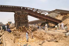 Workers repair a rail track that was washed away by flash floods at Ranpathani, near Karachi in Pakistan