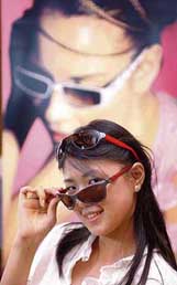 A woman displays two styles from the latest Ferrari eyewear glass range