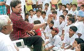 Kapil Dev gives bowling tips to budding cricketers at D.P. Azad Cricket Academy at St. Stephens, Sector 45, Chandigarh, on Wednesday