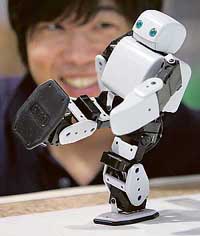 An employee of Japan's metalworking company Systec Akazawa looks at its humanoid robot