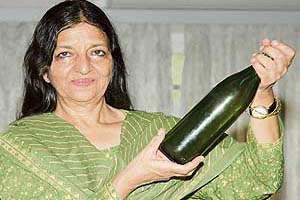 Architect Madhu Sarin holds a bottle of old wine from her cellar