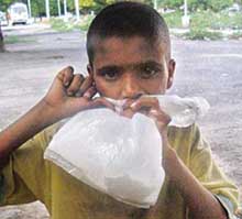 A ragpicker sucks fumes from a bag containing correction-fluid concoction.