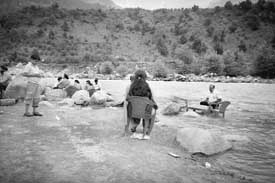 Tourists snacking in the cool waters of the Beas near Manali