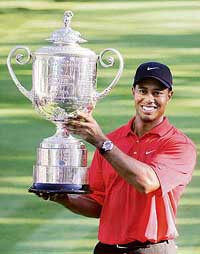 Tiger Woods of the USA holds the trophy after winning the PGA Golf Championship in Medinah, Illinois, on Sunday. 