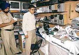 A police official accesses the loss after a theft at a mobile shop in Sector 47-D, Chandigarh, on Tuesday night.
