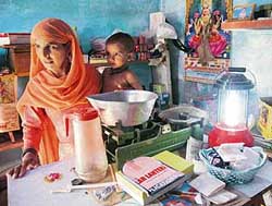 A woman at her shop with a solar lantern.