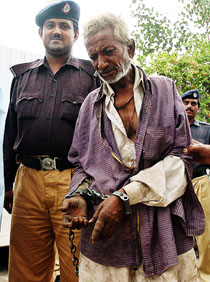 Pakistani policemen escort suspected Indian national Madan Lal to a court after he was arrested for stealing a railway engine in Karachi