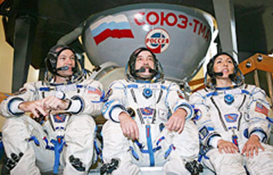 US astronaut Michael Lopez-Alegria, Russian cosmonaut Mikhail Tyurin and US entrepreneur Anousheh Ansari sit in front of a Soyuz space capsules in the Star City Space Centre outside Moscow