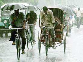 As rain lashed the city and its surrounding areas, workers take out umbrellas in Chandigarh on Friday morning.