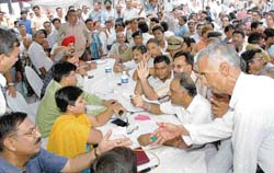 Applicants of the general category argue with HUDA officers during draw of plots for group housing societies at the HUDA office in Panchkula on Friday. 