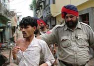cops whisk away a migrant labourer allegedly involved in stone-pelting incidentse