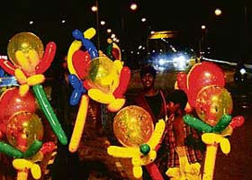 Street children make a living by selling colourful balloons at railway light point in Chandigarh
