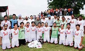 Members of the JCT Mills team pose with the trophy after winning the Punjab State Super Football League at the BSF football ground in Jalandhar