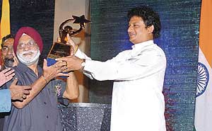 Indias Chef-de-Mission Rangil Singh (left) receives the South Asian Games champions trophy from Sri Lankan Sports Minister Jeevan Kumaratunga in Colombo on Sunday night.