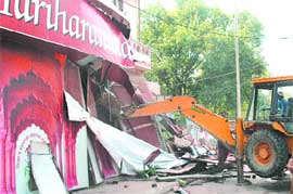 An MCD bulldozer demolishing a school building in Yamuna Bazar area on Thursday. 
