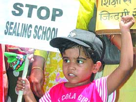 A child waves a placard and shouts slogans during a demonstration near Parliament House to protest against the government's sealing of schools in the residential areas in the Capital on Thursday.