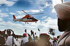 People wave to Mr Janardhan Divedi, general secretary of the AICC, as his chopper prepares to land near Kotli village on the death anniversary of Beant Singh, former Chief Minister of Punjab
