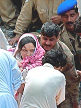 Pakistani army troops and volunteers rescue a woman survivor from the rubble of a collapsed building in Muree, 65 km northeast of Islamabad, on Thursday.  An earthquake-damaged seven-storey apartment building, which had been previously ordered to be demolished, collapsed in the mountain resort of Muree, killing the building's owner, his wife and their son.