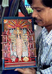 Mr Shyam Prasad Dey exhibits his creation, an idol of Goddess Durga, made of pencils in Kolkata on Friday.