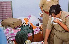 A police official inspects the house where a 70-year-old widow was found murdered