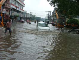 A car driver negotiates way through a waterlogged road in Ludhiana on Saturday.