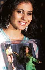Bollywood actress Kajol poses with a doll during a promotional event of a toy company in Mumbai