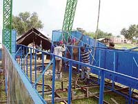 Unskilled workers raise a giant wheel at Chhapar Mela near Ahmedgarh on Monday.